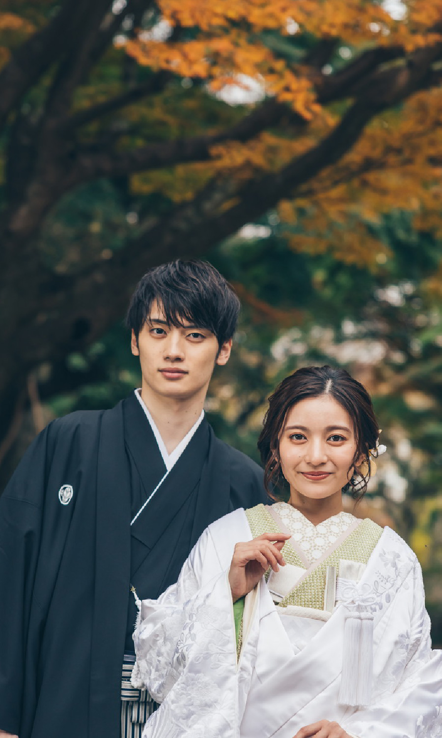 紅葉の下で微笑む新郎新婦様の結婚写真