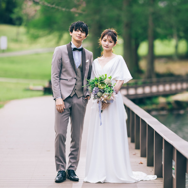 池の前でブーケを持った新婦様と新郎様が並んでいる結婚写真