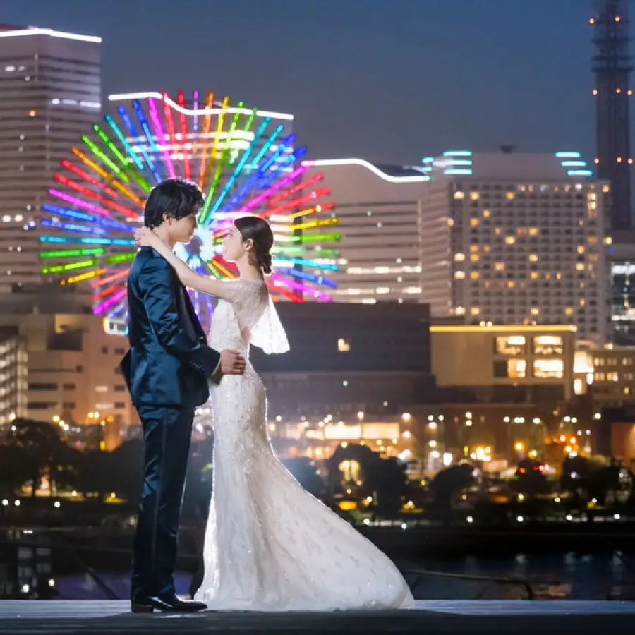 美しいみなとみらいの夜景をバックに抱き合う新郎新婦様のナイトロケーションフォト