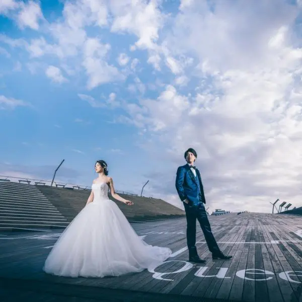 デッキの上で凛々しい表情をして並んでいる新郎新婦様の結婚写真