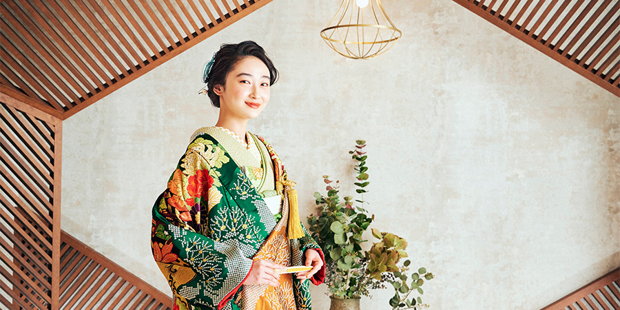 温かみのある木組みの背景セットで扇子を持って微笑む新婦様
