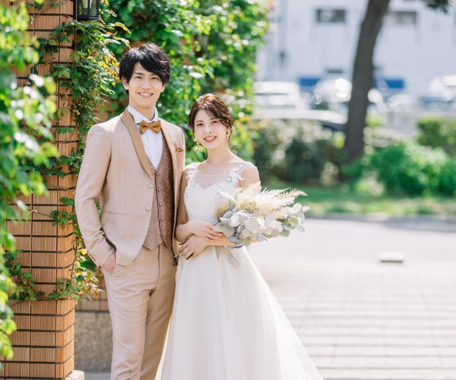 笑顔で花束を抱える新婦様と新郎様の結婚写真