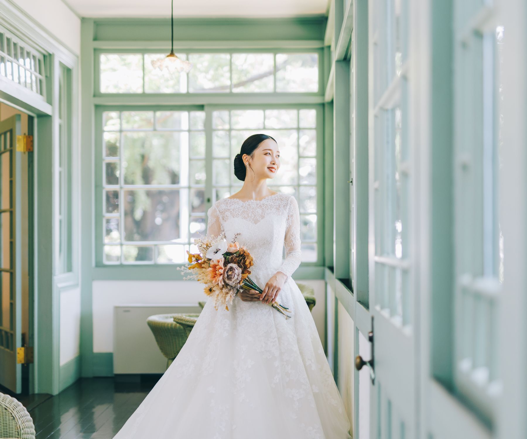 花束をもって微笑む新婦様のウェディングフォト