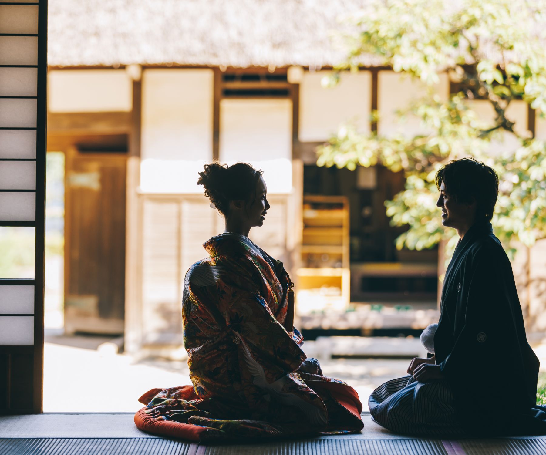 縁側で談笑する新郎新婦様のシルエットショット