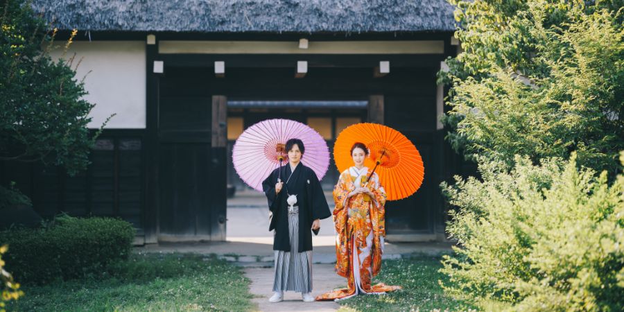 横溝屋敷の前で和傘をさす新郎新婦様の結婚写真