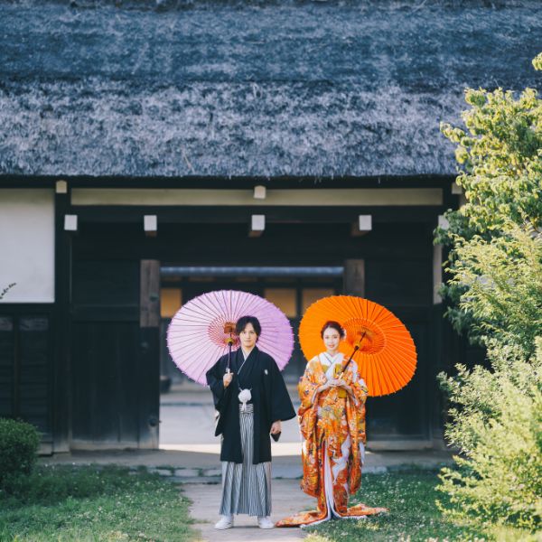 横溝屋敷の前で和傘をさして佇む新郎新婦様の結婚写真